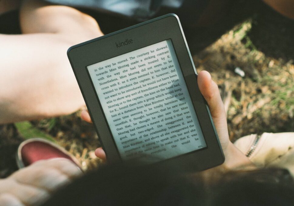 person holding black Amazon Kindle e-book reader